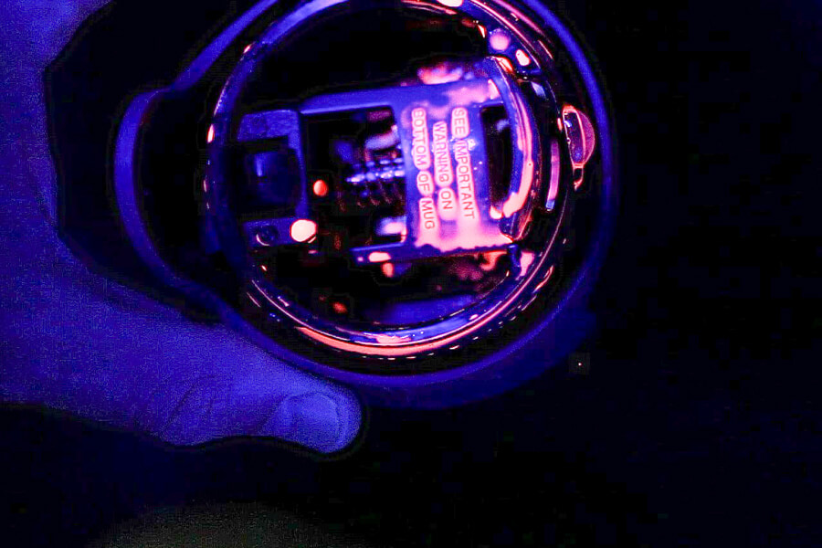 a lid with UV paint in a black light for the cleaning test