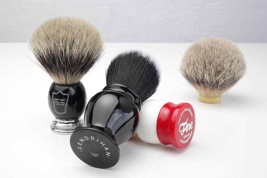three shaving brushes and a loose knot of hair