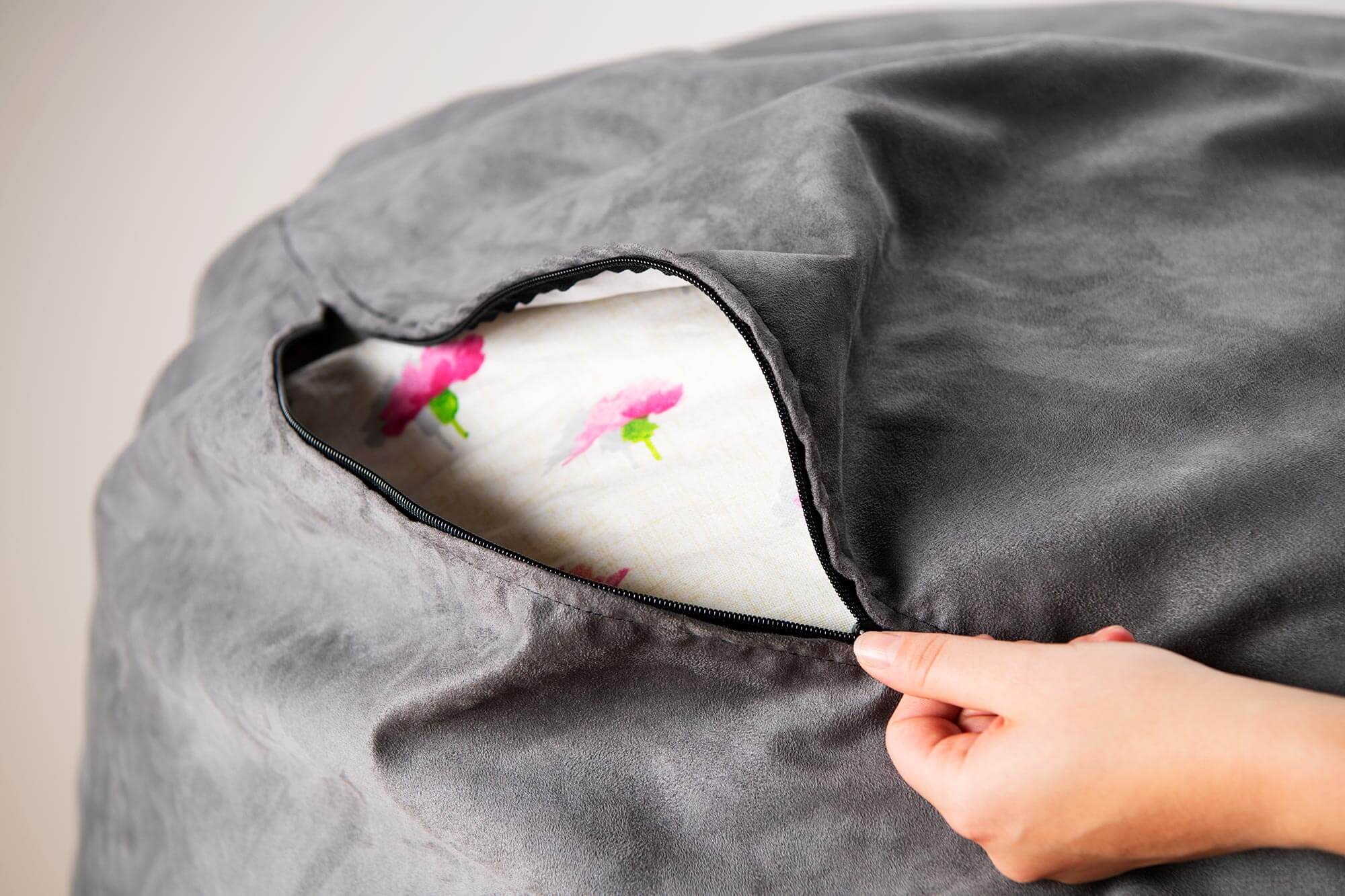 Person's hand unzipping bean bag outer cover