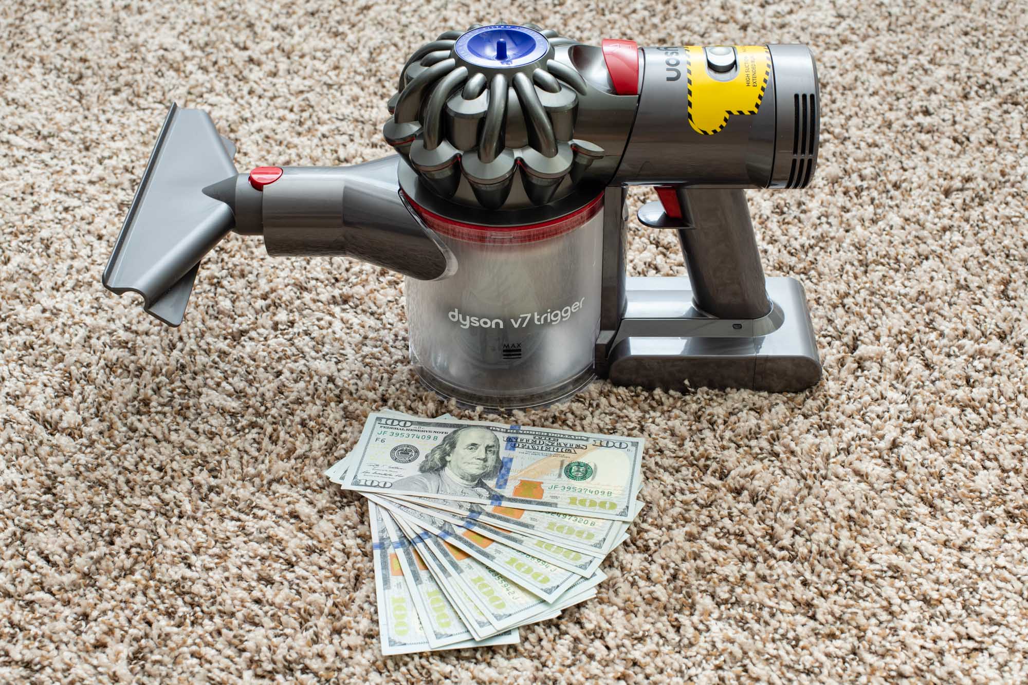 the pricey Dyson V7 next to a pile of cash
