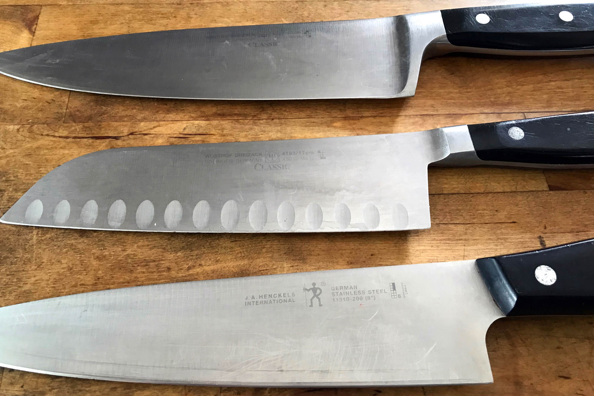 Three different style knives on butcher block