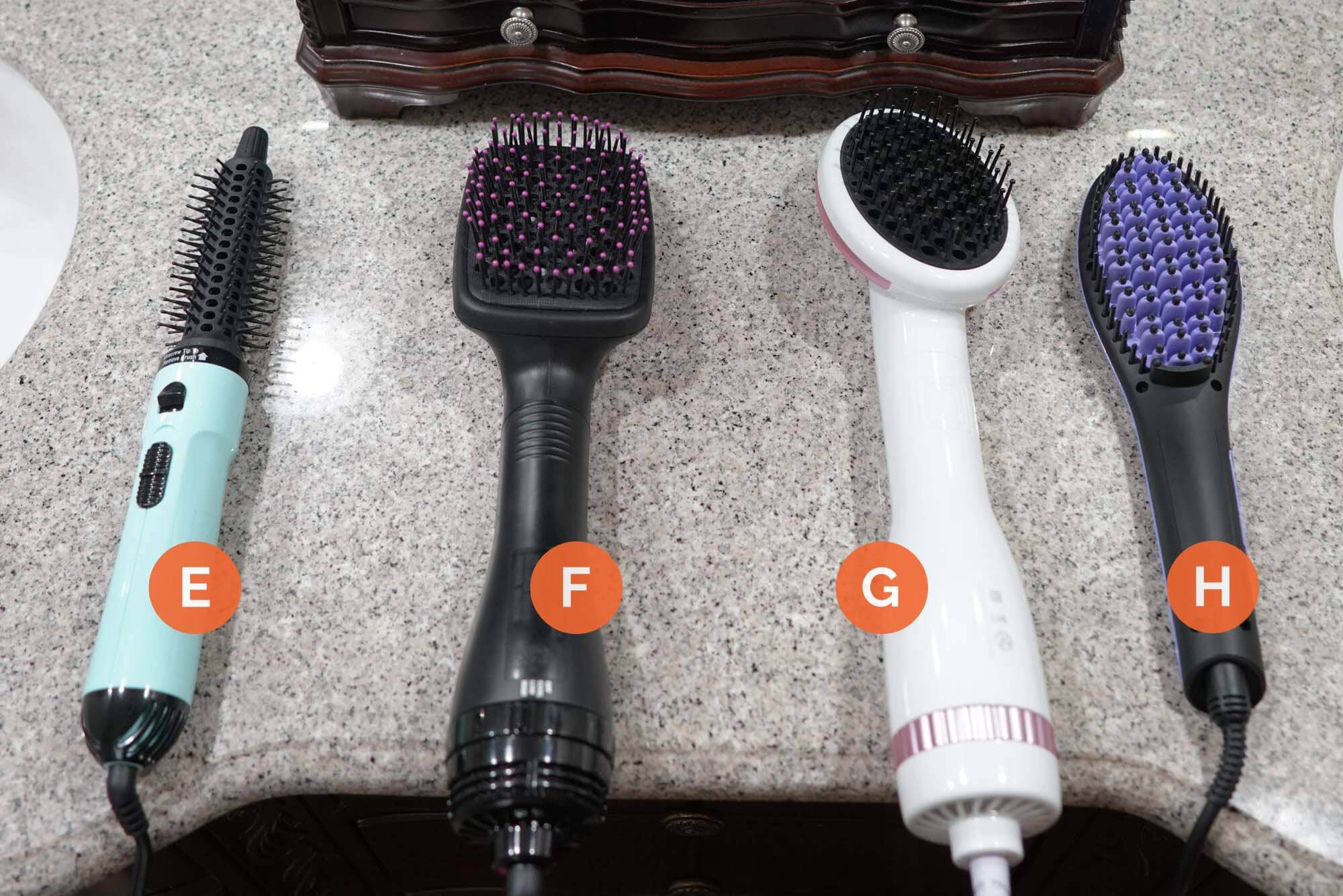 Four straightening brushes lined up on counter