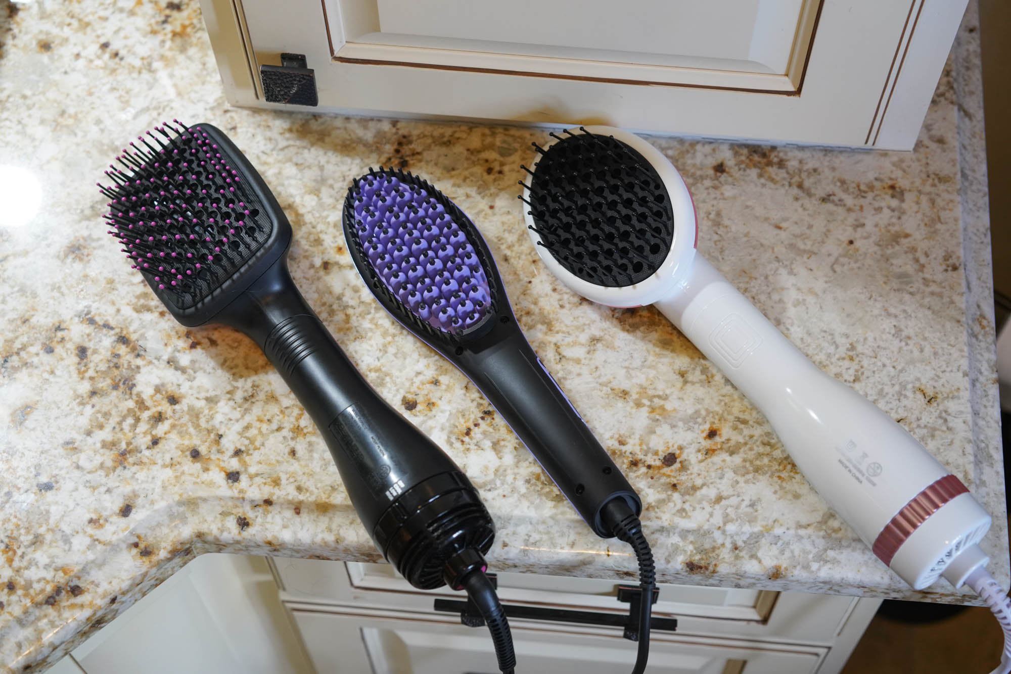 Three hair straighteners on counter