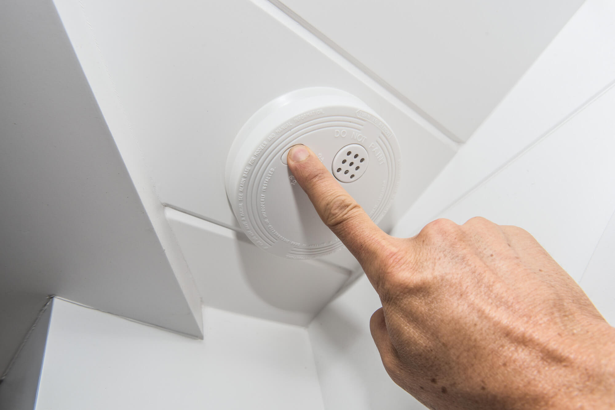 Smoke detector with finger on test button