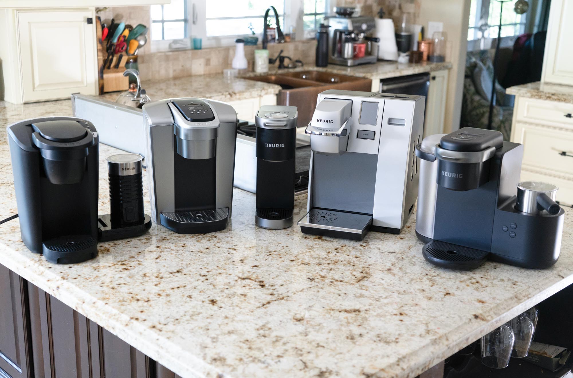 Coffee makers lined up on granite counter top.