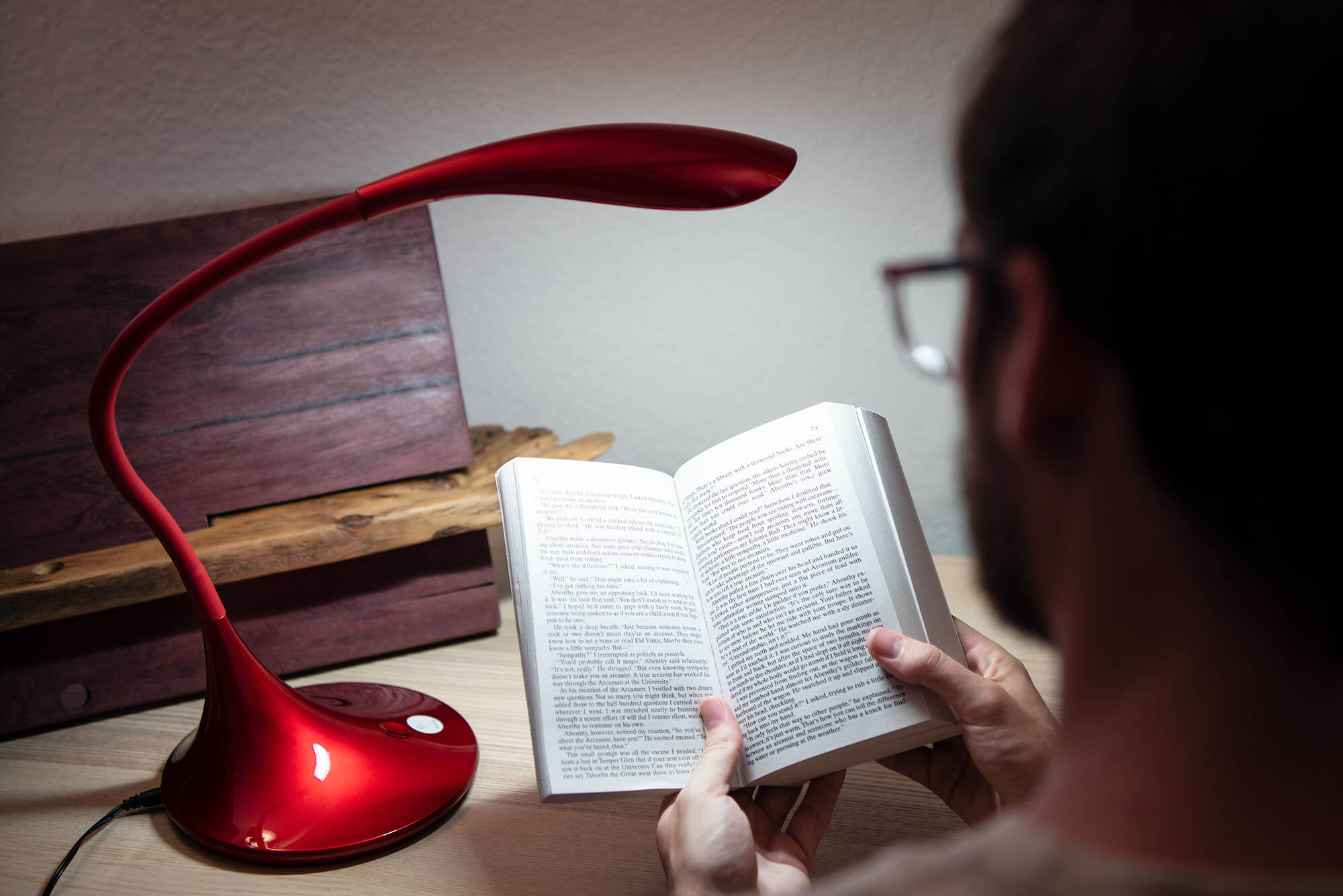bearded man reading a book with a light