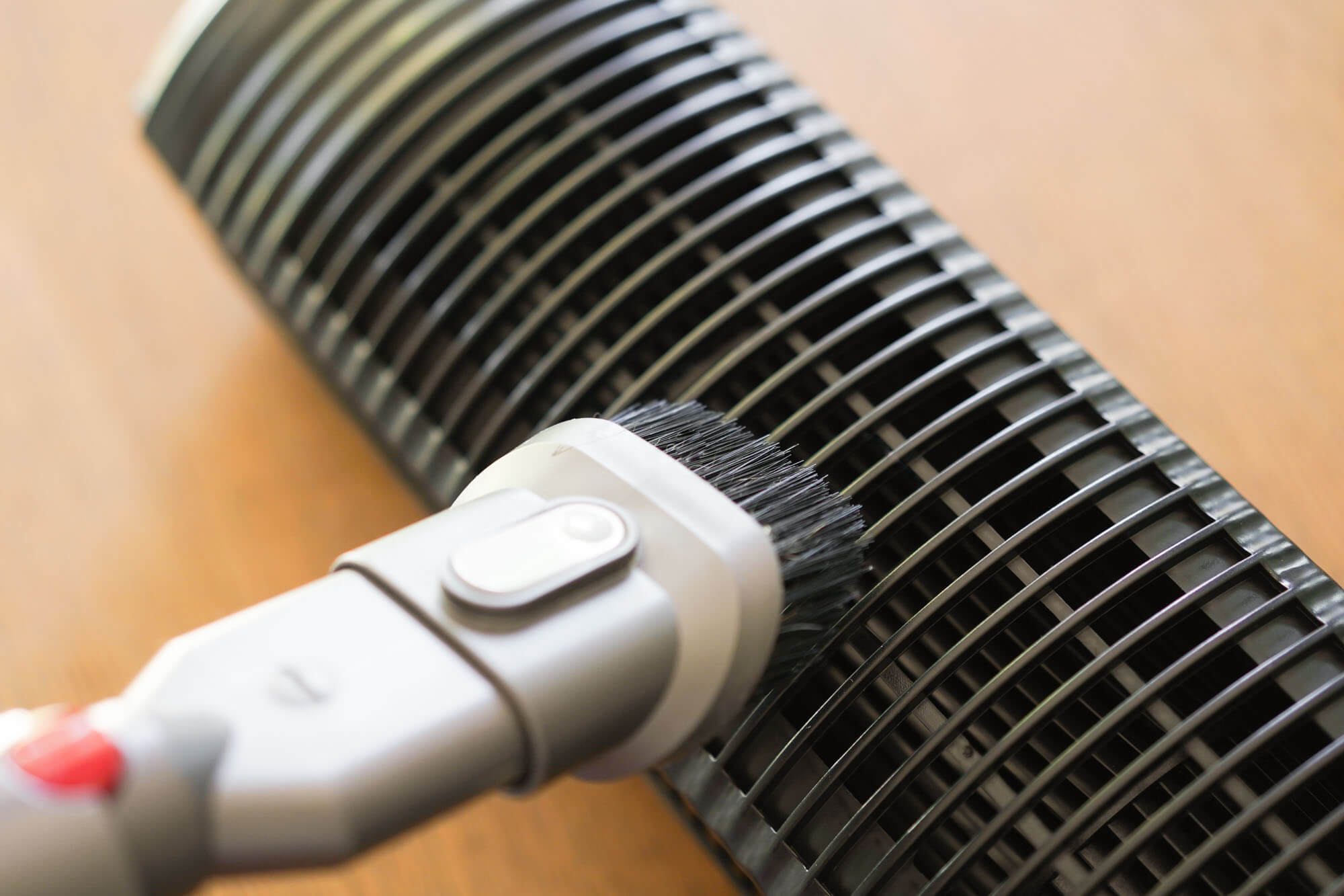 vacuuming fan vents with a brush attachment